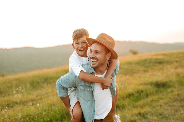 istock A mature father standing and holding a toddler son, having fun. 1190246663
