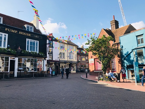 Tenterden, England - April 17, 2019: People stand by the historic Town Hall at Tenterden in Kent. The building dates from 1790. The Woolpack pub and hotel stands next door.