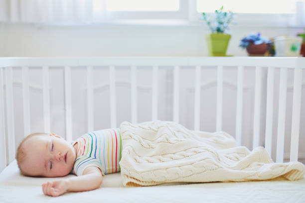 istock Baby sleeping in co-sleeper crib attached to parents' bed 1190247697