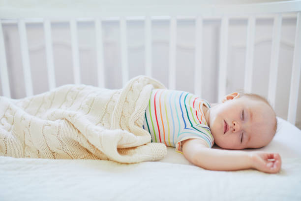 istock Baby sleeping in co-sleeper crib attached to parents' bed 1190247839