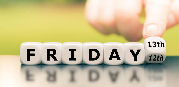 hand turns a dice and changes the expression "friday 12th" to "friday 13th". - friday the 13th imagens e fotografias de stock