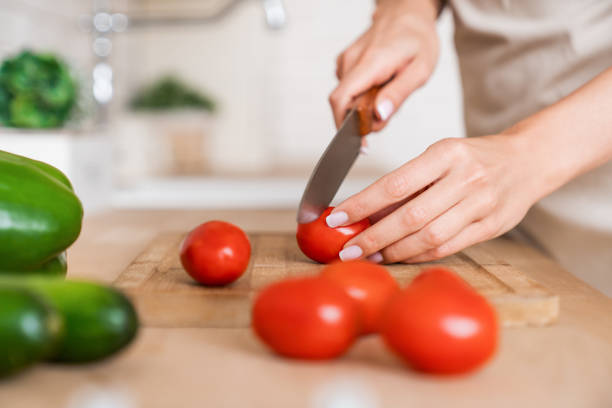 istock Close up on housewife cutting vegetables in kitchen 1190252862
