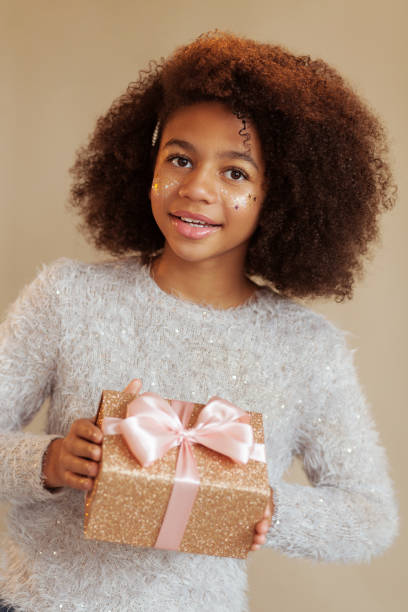 istock Cute festive girl holding a sparkling gift box 1190255026