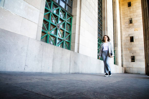 istock Confident millennial female college student walking on campus full length 1190258074