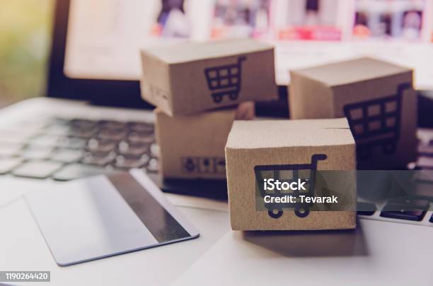 Online Shopping Paper Cartons Or Parcel With A Shopping Cart Logo And Credit Card On A Laptop Keyboard Shopping Service On The Online Web And Offers Home Delivery Stock Photo - Download Image Now