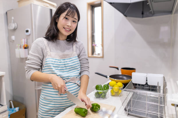 台所でコショウを切る妊婦の肖像画 - bell pepper pepper green bell pepper red ストックフォトと画像