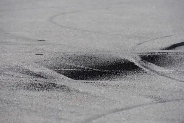 Black burnt rubber drift traces made by motorcycle on asphalt. Braking distances