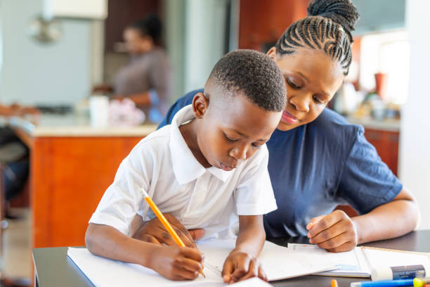 istock Mother Helping Her Son Do Homework at the Dining Room Table 1190274450