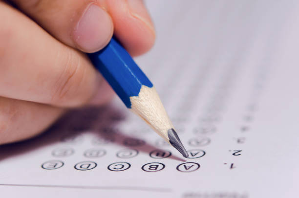 istock Students hand holding pencil writing selected choice on answer sheets and Mathematics question sheets. students testing doing examination. school exam 1190275245