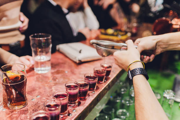 istock Bartender pouring strong alcoholic drink into small glasses on bar, shots. 1190277083