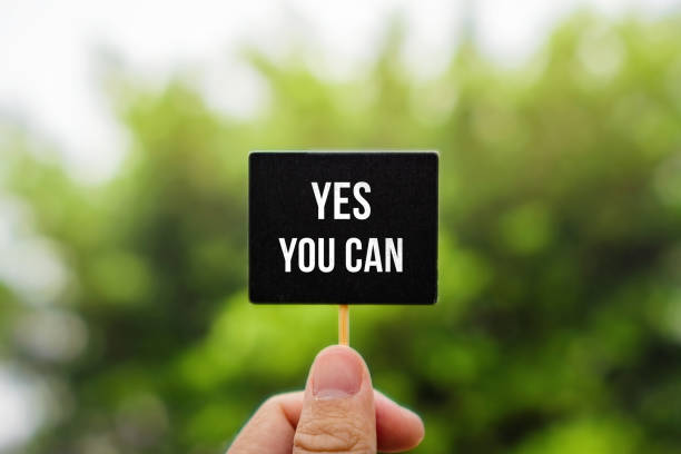 istock Yes You Can. Hand Holding Stick Blackboard. 1190278413