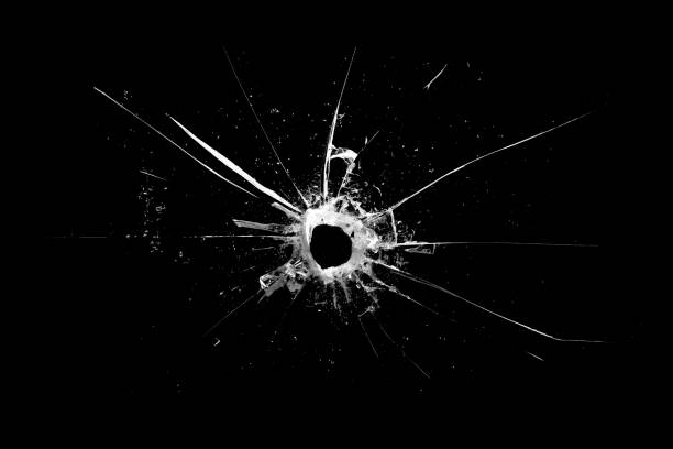 istock hole in the glass with cracks isolated on a black background 1190279562