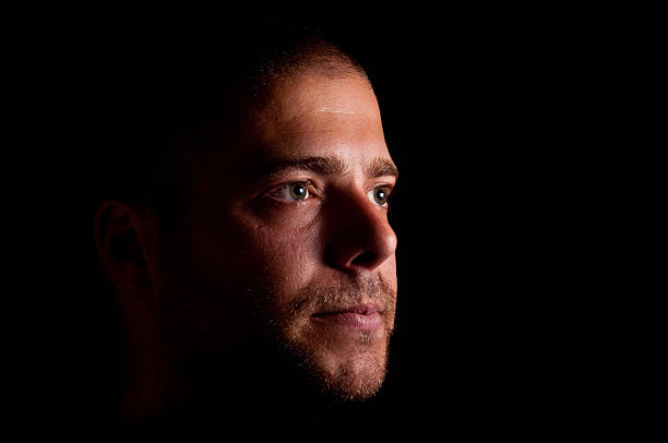 istock Unshaven man looking into the dark. 119028244