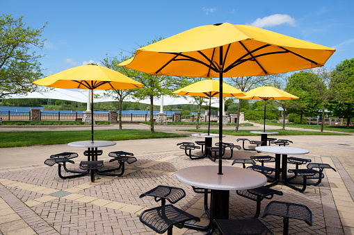 Resting area in park with seats, tables and parasol