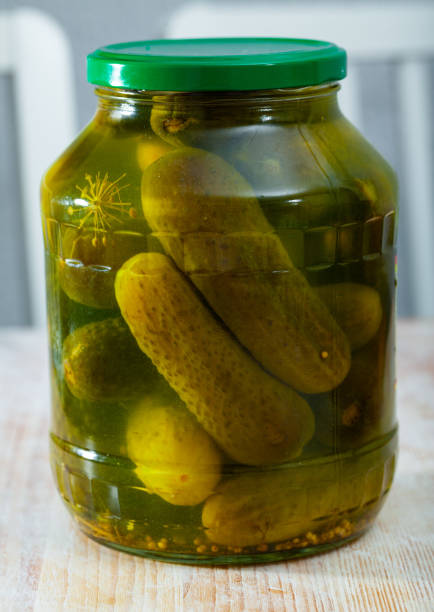 istock Glass jar with pickled cucumbers on a wooden table 1190284398