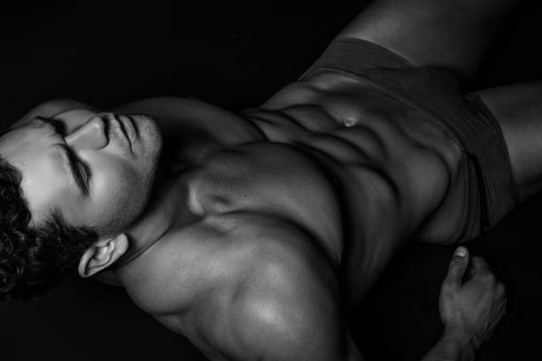 noir et blanc muscle fort beau portrait de modèle mâle dépouillé sur le fond de police d'isolement avec l'ombre - massage sensuel photos et images de collection