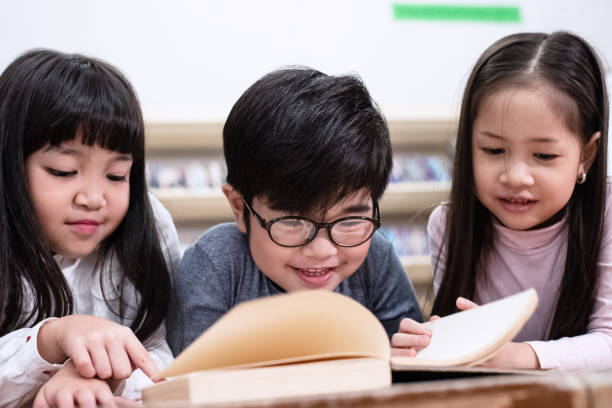 istock Group of children reading book at library,with interested feeling 1190294959