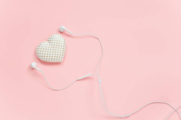 декоративный текстиль объем сердца и белые наушники на розовом фоне. концепция слушать свое сердце или любовь к музыке. верхний вид копия п� - pink and white radio стоковые фото и изображения