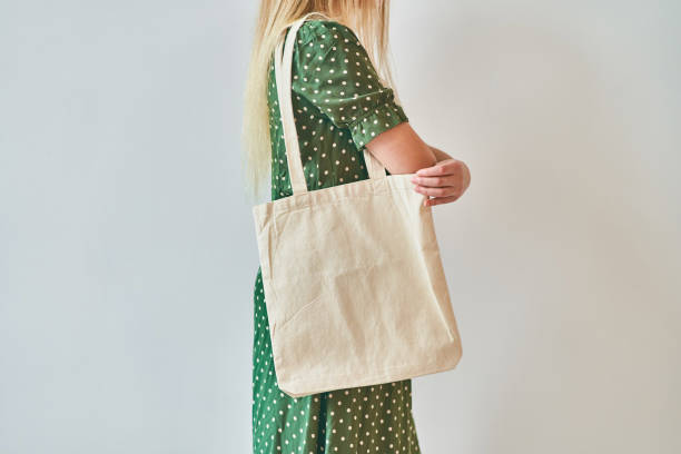une fille tient le sac blanc de fourre-tout d'éco de coton, maquette de conception. - tote bag photos et images de collection