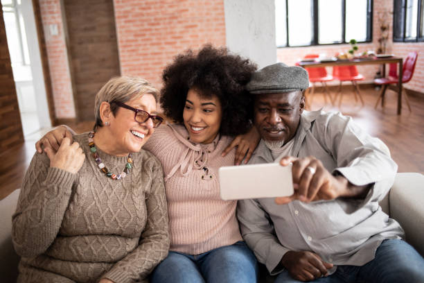 istock Multi-ethnic family taking selfie at home, embracing 1190302285