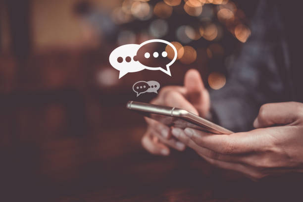 istock Women hand using smartphone typing, chatting conversation in chat box icons pop up. Social media maketing technology concept.Vintage soft color tone background. 1190305297