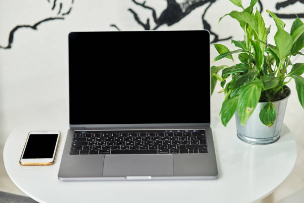 istock Laptop with a smartphone on a table in a cafe. 1190306384