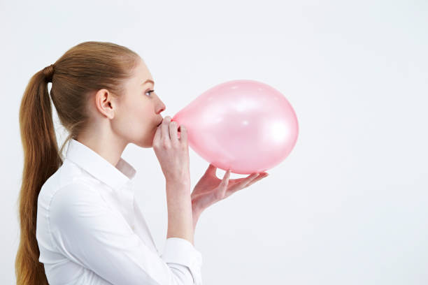 istock Caucasian woman blowing a balloon 1190311991
