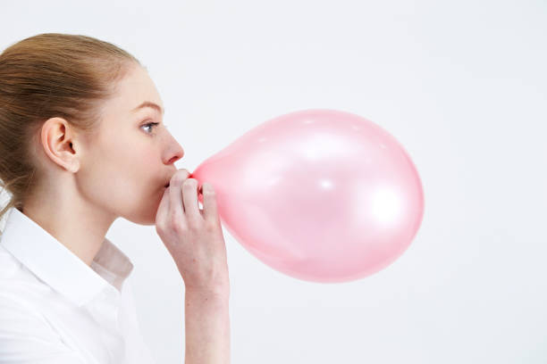 istock Caucasian woman blowing a balloon 1190312025