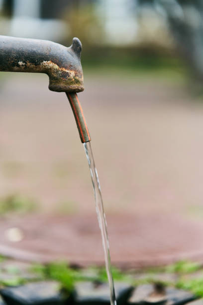 istock Old iron column. Water is pouring from a street column 1190317155