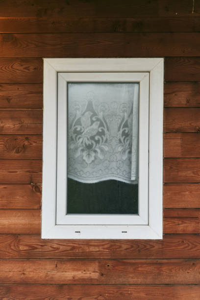 Plastic window in a wooden house. Close-up.