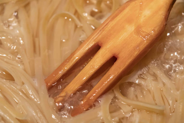 istock spaghetti pasta in pot and wooden fork 1190324375