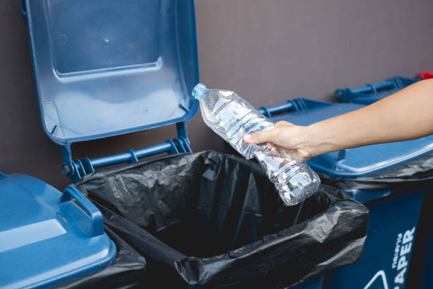 istock Close up hand throwing empty plastic bottle into the trash, recycling concept 1190324589