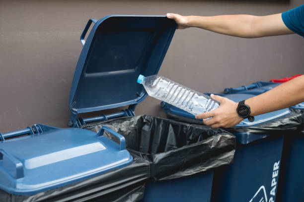 istock Close up hand throwing empty plastic bottle into the trash, recycling concept 1190324595