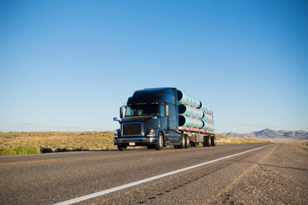 semi truck carrying construction materials on highway - clear sky sky sunny day isolated imagens e fotografias de stock