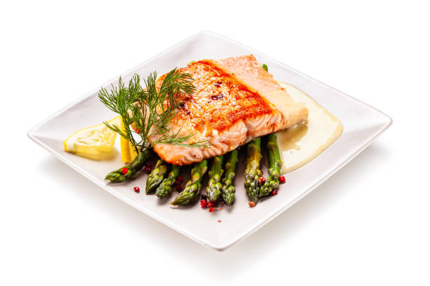 istock Fried salmon with asparagus on white background 1190329748