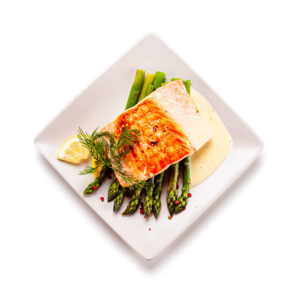istock Fried salmon with asparagus on white background 1190329801