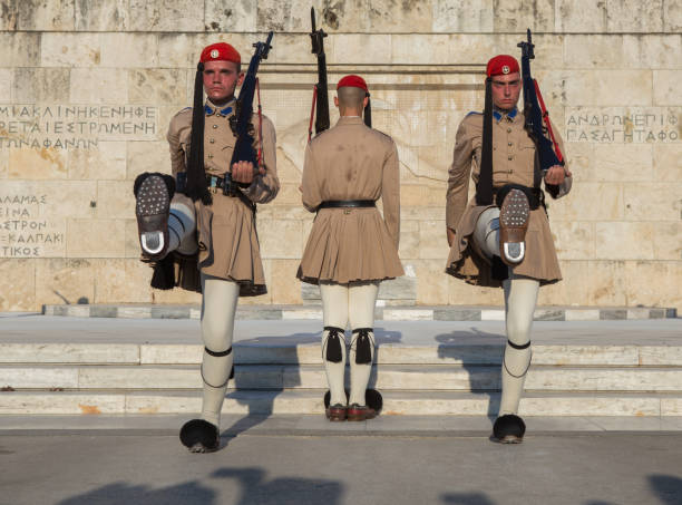 atenas, grécia - 29 agosto 2019: as pessoas estão assistindo a cerimônia oficial da guarda presidencial (os chamados "evzones") em frente ao monumento do soldado desconhecido, perto da praça syntagma, em atenas, grécia. - syntagma square - fotografias e filmes do acervo
