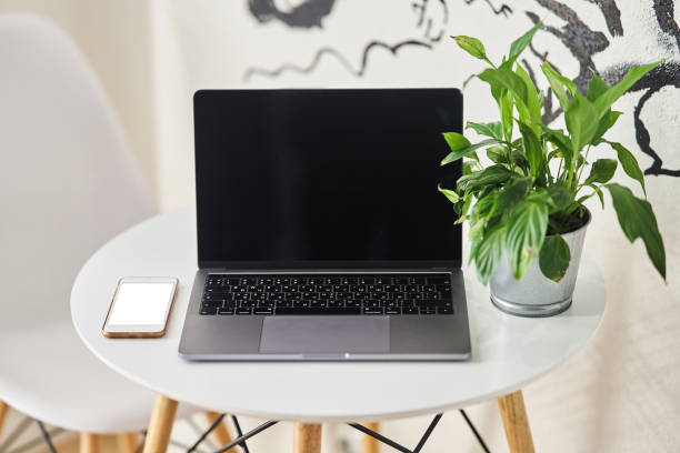 istock Laptop with a smartphone on a table in a cafe. 1190343164