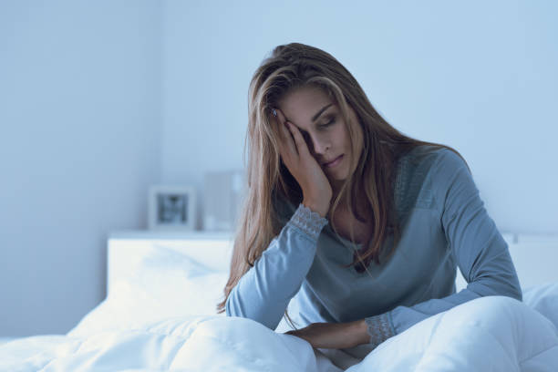 Mulher deprimida acordada no meio da noite Mulher deprimida acordada no meio da noite, ela está tocando a testa e sofrendo de insônia Pessoas exaustas fotos de stock, fotos e imagens livres de direitos autorais