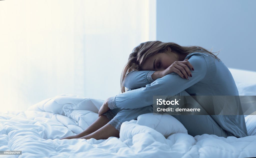 Depressed woman awake in the night Depressed woman awake in the night, she is exhausted and suffering from insomnia Sleeping Stock Photo