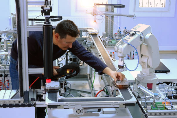 istock industry 4.0 concept: An engineer is holding product and teaching robotic arm the positions with teach pendant 1190347637