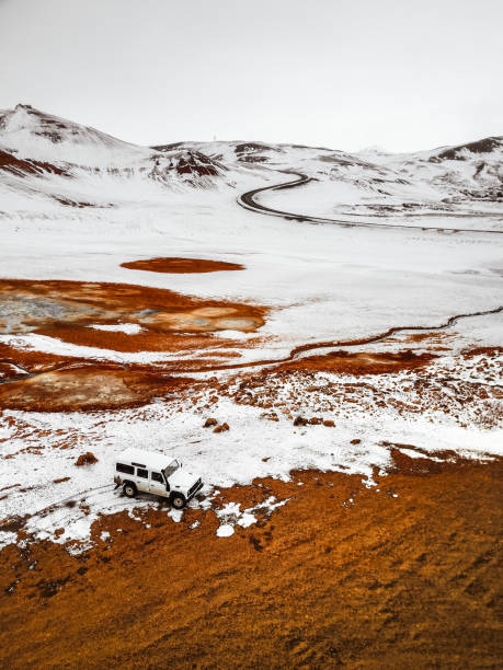 Hofn, Iceland - April 15, 2017: Old white Land Rover Defender 4x4 SUV parked in the snowed parking spot in Geysir, Iceland. Cloudy day with all the ground full of ice.