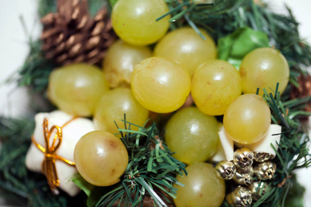 istock Twelve white grapes displayed on Christmas decorations. 1190349638
