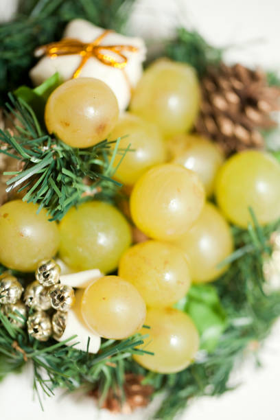 A cluster of an Organic fresh seedless red grapes in a transparent bowl isolated on a white background, selective focus of red grapes in a plate