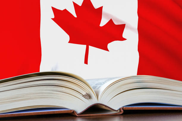 Education in Canada. Opened book and national flag on background. stock photo