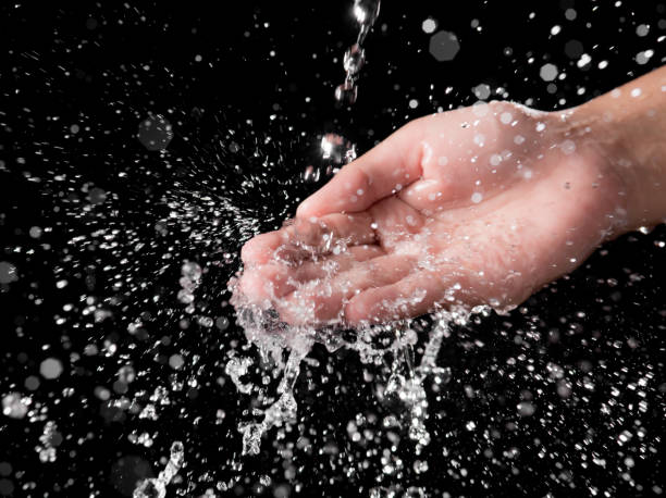 istock Hand and splashing water on black background 1190353936