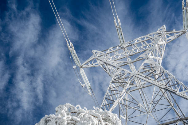 Electric pylon and snow High voltage electric tower on a snowy day in the mountains power mast stock pictures, royalty-free photos & images