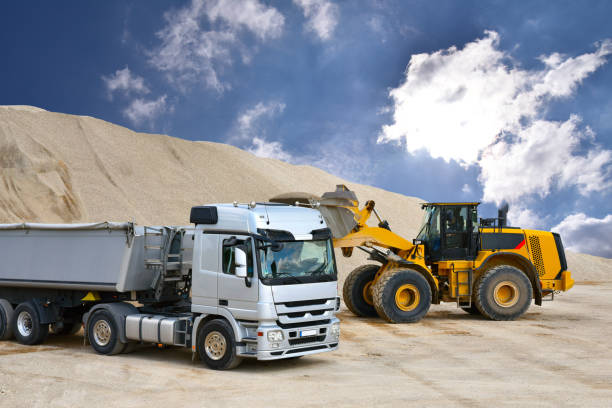 istock Wheel loader loads a truck with sand in a gravel pit 1190355896