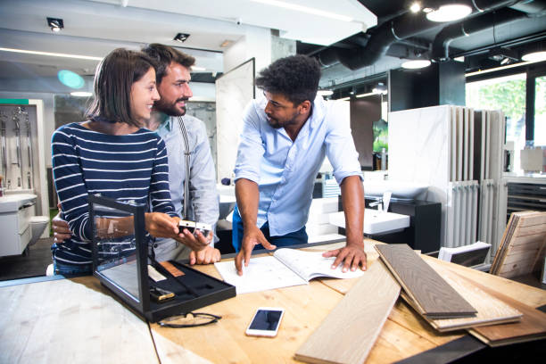 istock Customer couple choosing a faucet handle from a luxurious display case with a store salesperson giving them assistance in choosing 1190357345