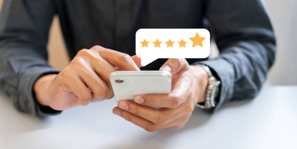 close up on businessman hand pressing on smartphone screen with gold five star rating feedback icon and press level excellent rank for giving best score point to review the service , technology business concept - rating ranking quality control aspirations imagens e fotografias de stock